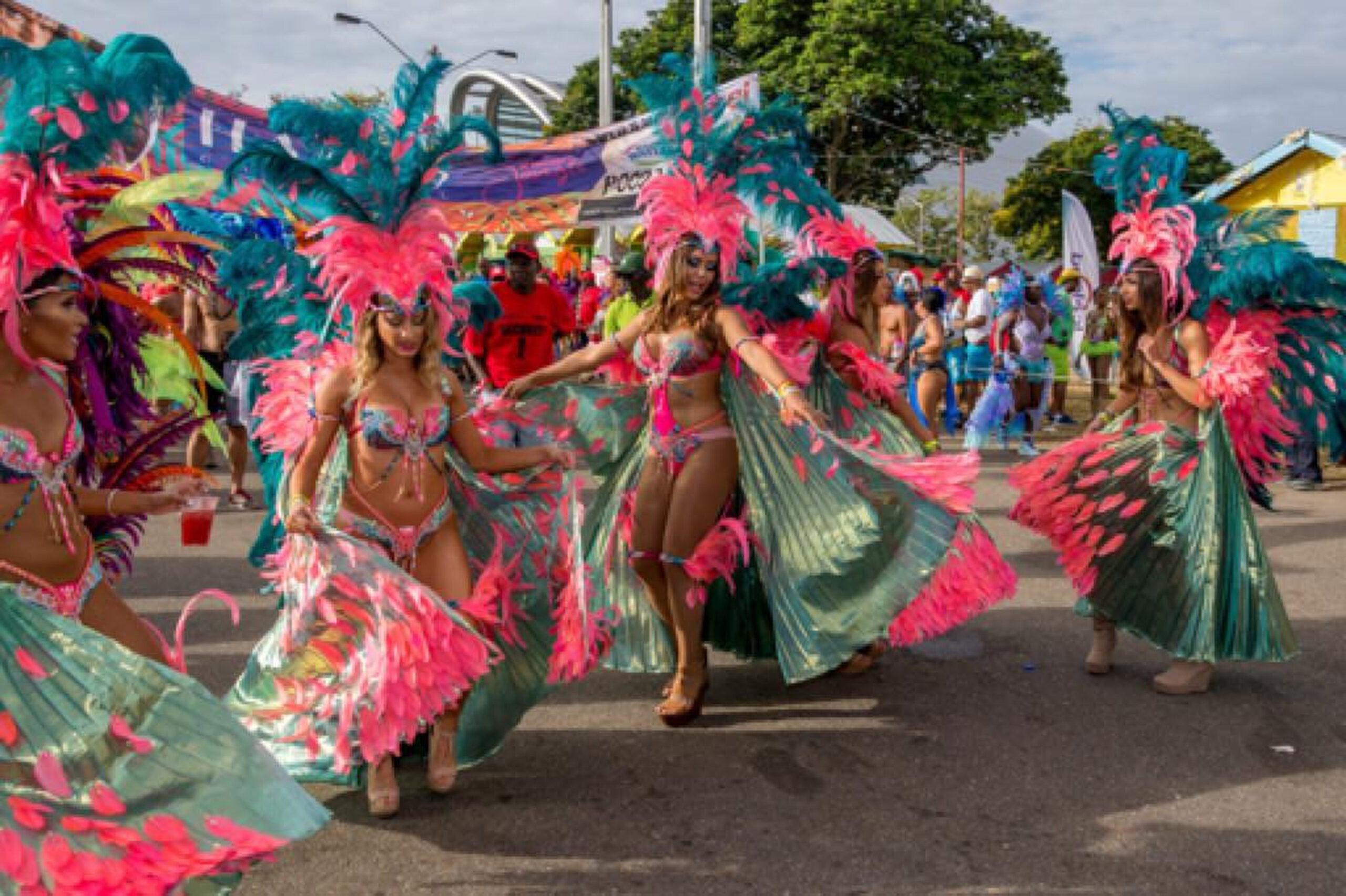 Masqueraders in colourful feathered costumes dancing through the streets of Port of Spain during Trinidad Carnival