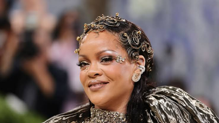 Rihanna at a formal red‑carpet event in 2026, wearing a metallic gown and jewelled headpiece.